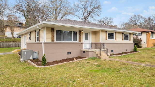 view of front of home with a front yard, central AC unit, brick siding, and crawl space