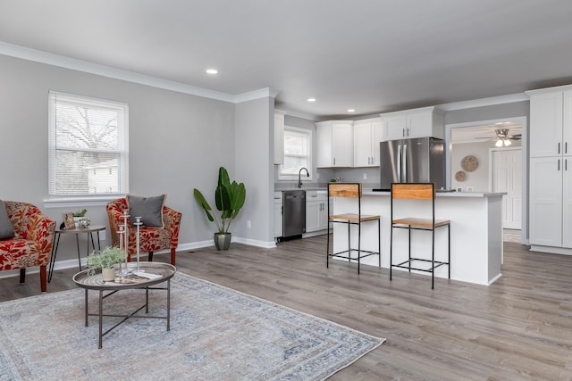 interior space with crown molding, baseboards, ceiling fan, recessed lighting, and light wood-style floors