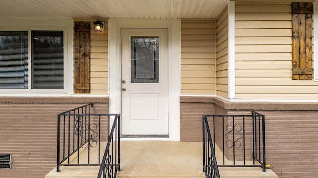 property entrance featuring brick siding