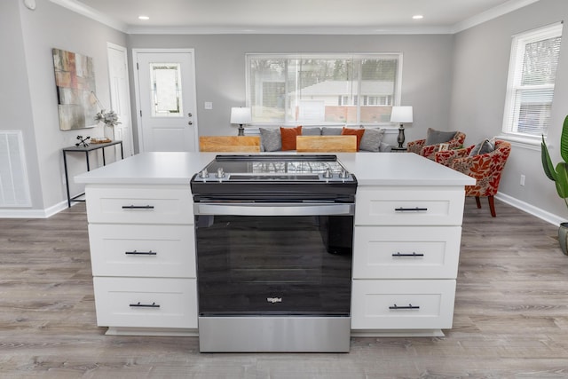 kitchen featuring stainless steel electric stove, plenty of natural light, crown molding, and visible vents