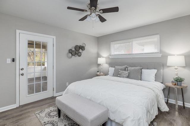 bedroom with baseboards, multiple windows, and wood finished floors