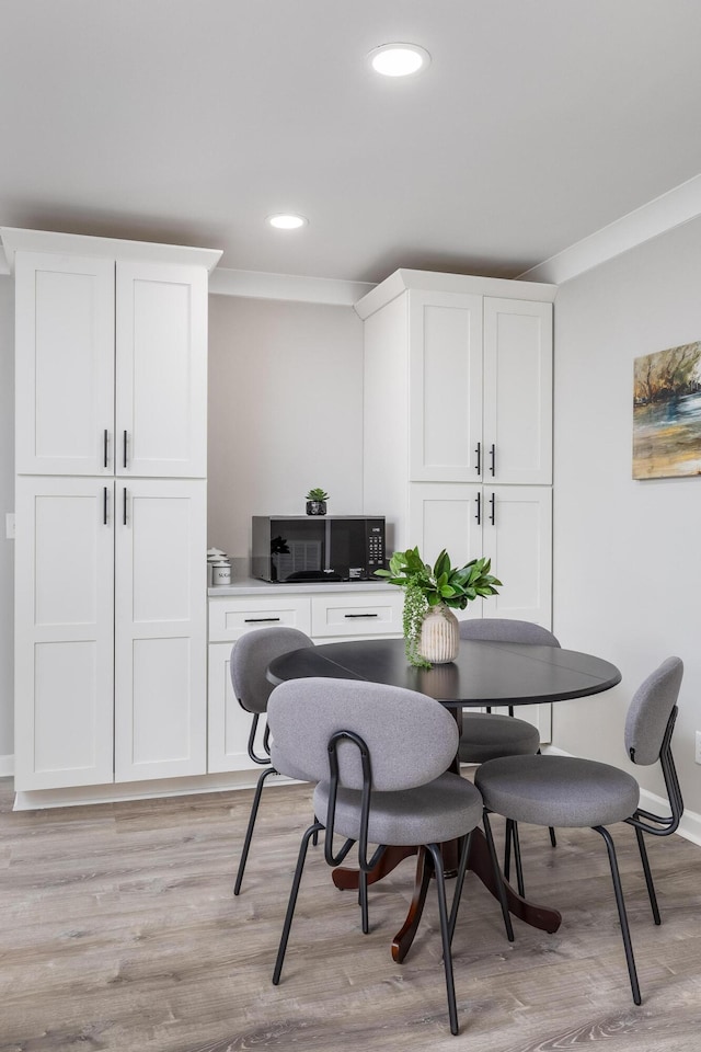 dining space with crown molding, recessed lighting, baseboards, and light wood finished floors