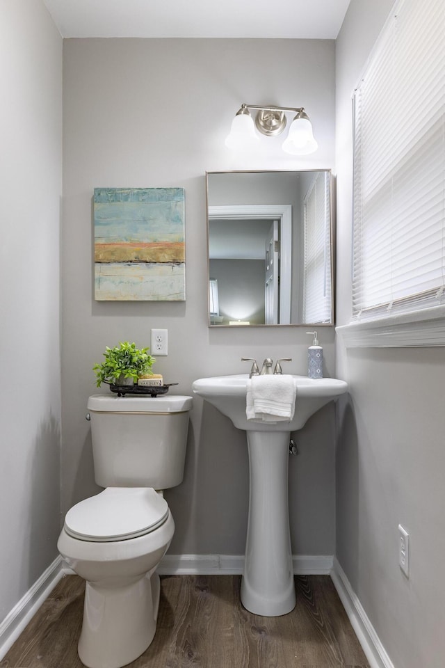 bathroom featuring toilet, wood finished floors, and baseboards