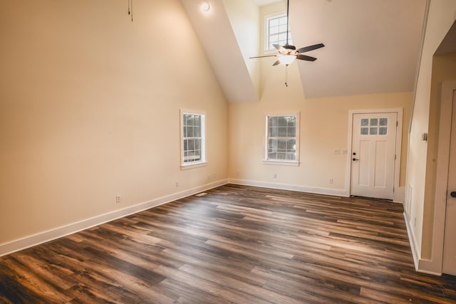 unfurnished living room with dark hardwood / wood-style flooring, plenty of natural light, high vaulted ceiling, and ceiling fan