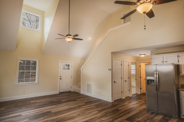 unfurnished living room featuring dark hardwood / wood-style flooring, high vaulted ceiling, and ceiling fan