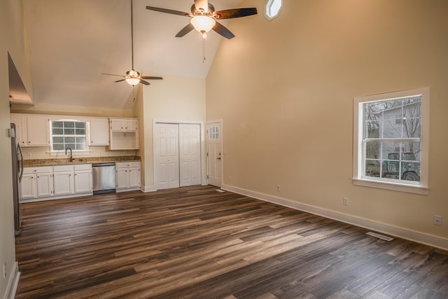 kitchen with sink, high vaulted ceiling, stainless steel appliances, dark hardwood / wood-style floors, and white cabinets