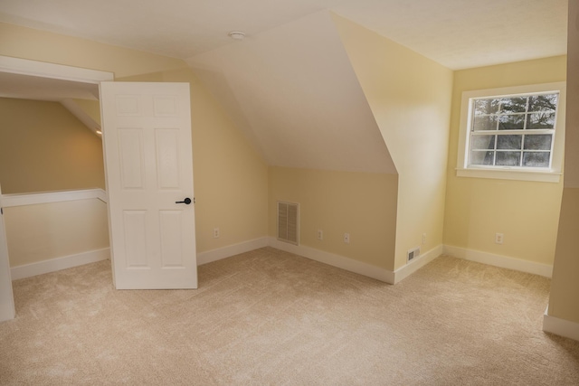 bonus room with light carpet and vaulted ceiling