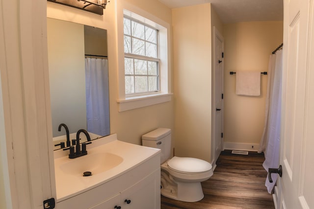 bathroom featuring vanity, wood-type flooring, and toilet