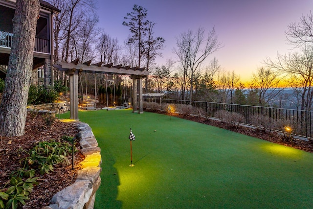 yard at dusk featuring a pergola