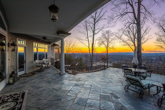 patio terrace at dusk featuring ceiling fan