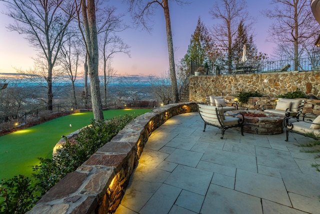 patio terrace at dusk featuring a fire pit