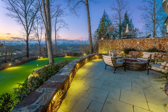 patio terrace at dusk featuring a fire pit