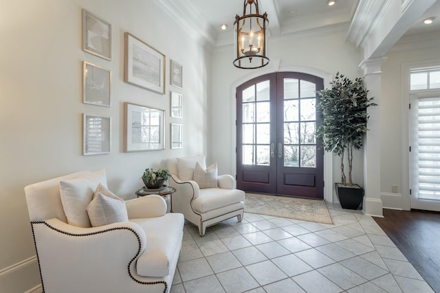 tiled foyer entrance with ornamental molding, a towering ceiling, beam ceiling, and french doors