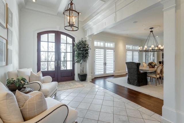 entryway with french doors, ornamental molding, light tile patterned floors, and a notable chandelier