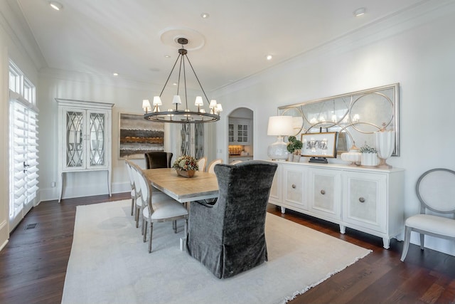 dining room featuring crown molding, dark wood-type flooring, and a chandelier