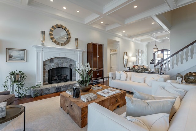 living room with coffered ceiling, a fireplace, light hardwood / wood-style floors, and beamed ceiling