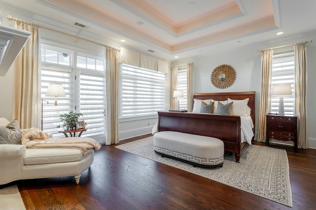 bedroom featuring ornamental molding, dark hardwood / wood-style floors, a raised ceiling, and multiple windows