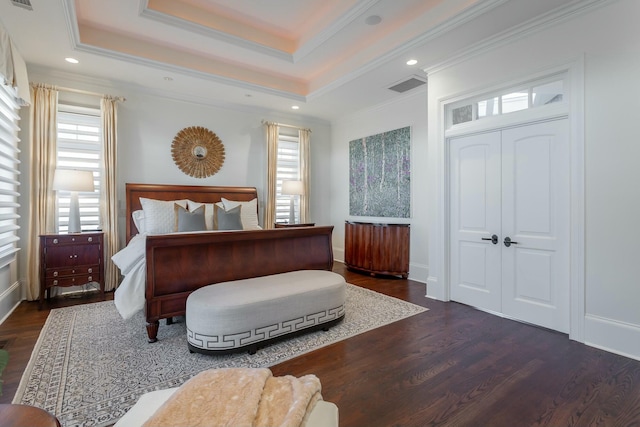 bedroom featuring a raised ceiling, ornamental molding, dark hardwood / wood-style flooring, and a closet