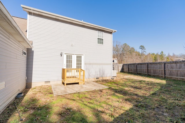 back of property with a yard and a patio