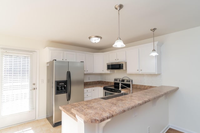 kitchen with kitchen peninsula, pendant lighting, stainless steel appliances, decorative backsplash, and white cabinets