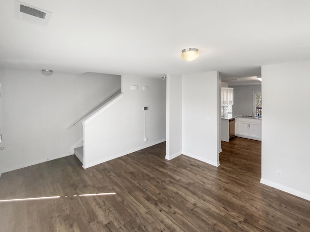 unfurnished living room featuring sink and dark hardwood / wood-style floors