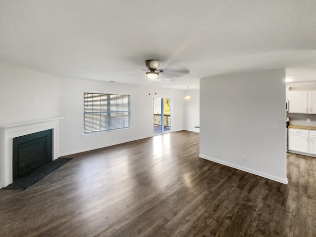 unfurnished living room featuring ceiling fan and dark hardwood / wood-style floors