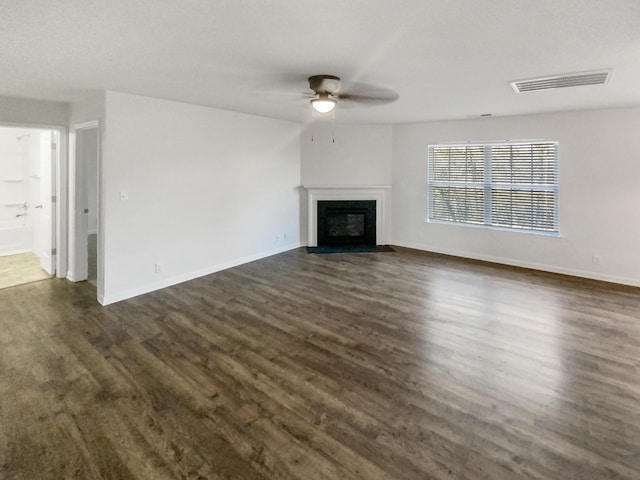 unfurnished living room with dark wood-type flooring and ceiling fan