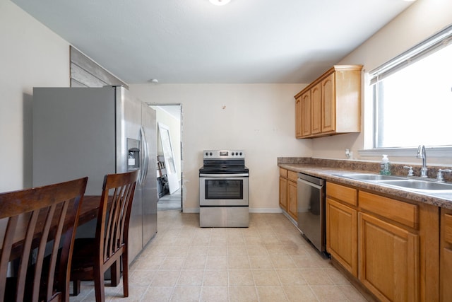 kitchen with sink, light tile patterned flooring, and appliances with stainless steel finishes