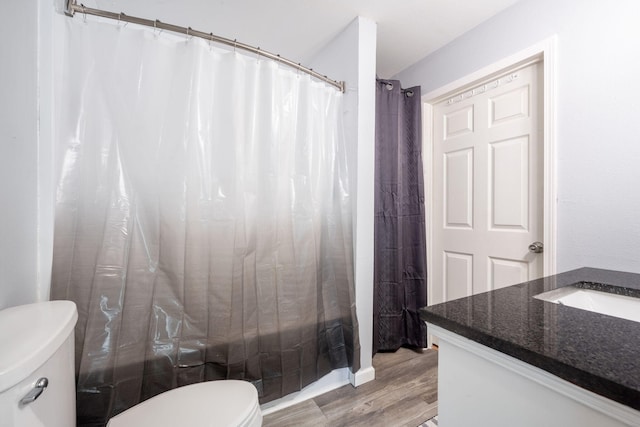 full bathroom with wood-type flooring, vanity, shower / bath combo with shower curtain, and toilet