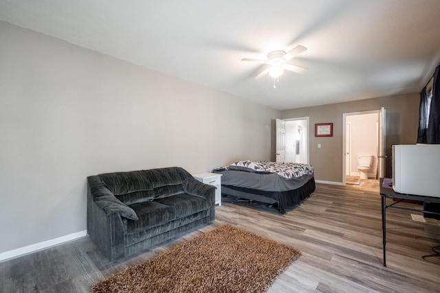 bedroom with ceiling fan, wood-type flooring, and connected bathroom