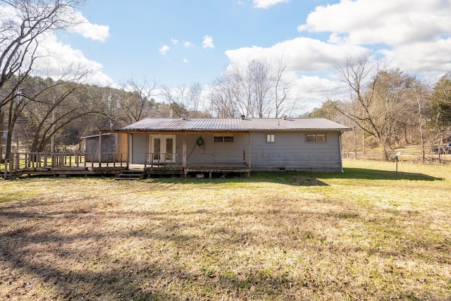 rear view of property with a wooden deck and a yard