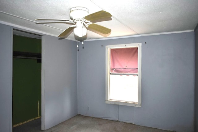 unfurnished bedroom featuring carpet flooring, a textured ceiling, ceiling fan, and a closet