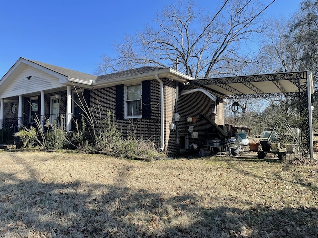 view of home's exterior with a porch and a lawn