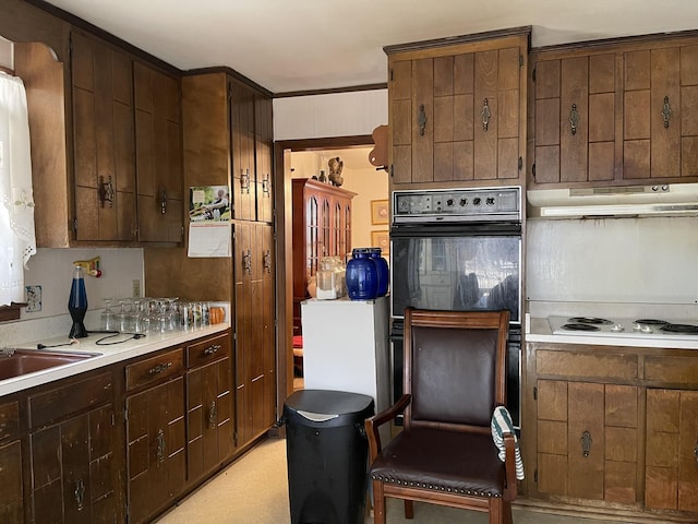 kitchen featuring white electric cooktop, dark brown cabinetry, and black double oven