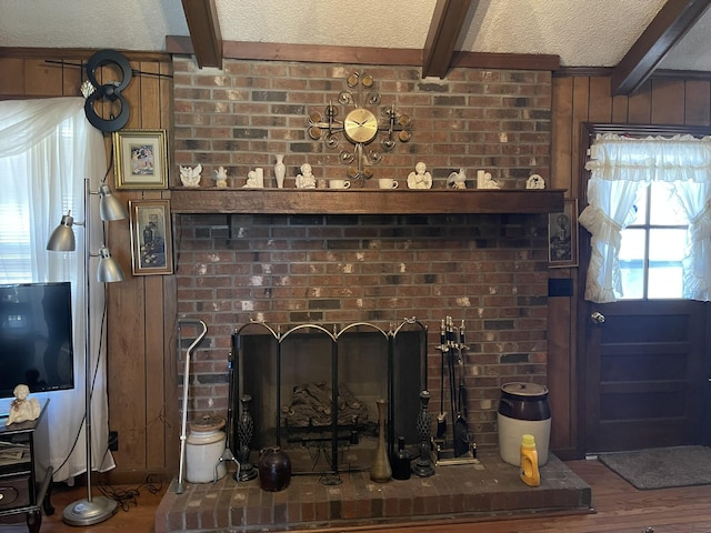 details with beamed ceiling, a brick fireplace, a textured ceiling, and hardwood / wood-style flooring