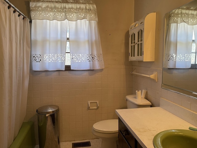 full bathroom featuring vanity, plenty of natural light, tile walls, and toilet