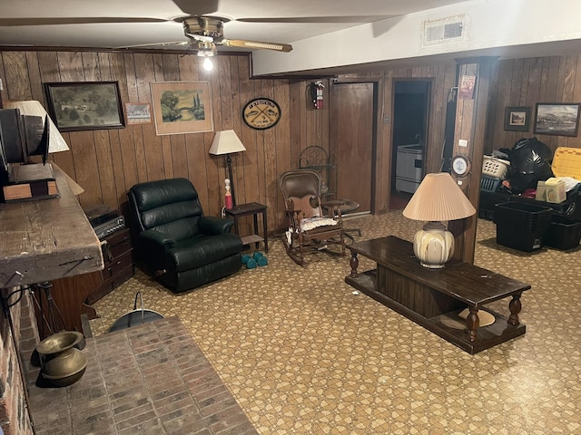 living room with ceiling fan and wood walls