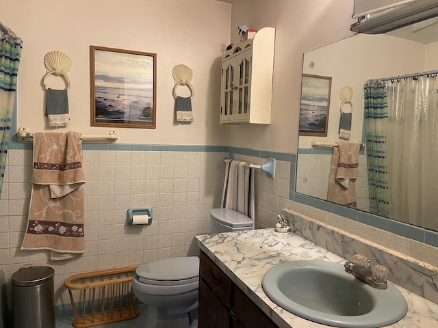 bathroom with vanity, tile walls, toilet, and a shower with shower curtain