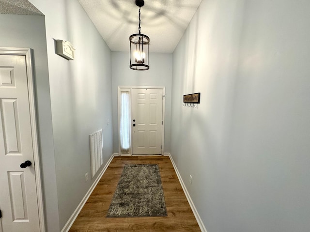 doorway featuring dark hardwood / wood-style flooring and a chandelier