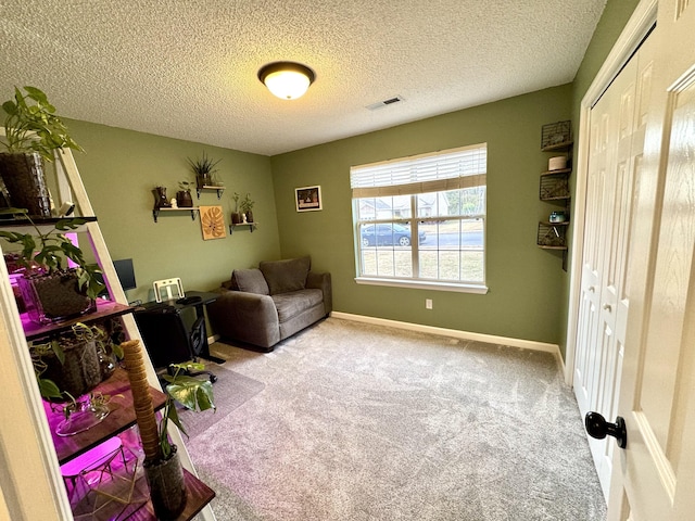 living area with light carpet and a textured ceiling