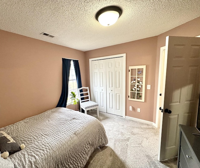 bedroom featuring carpet floors, a textured ceiling, and a closet