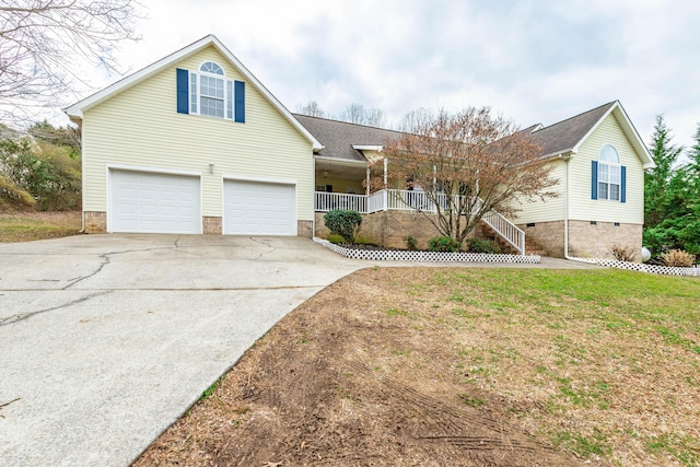 front facade with a porch, a garage, and a front yard