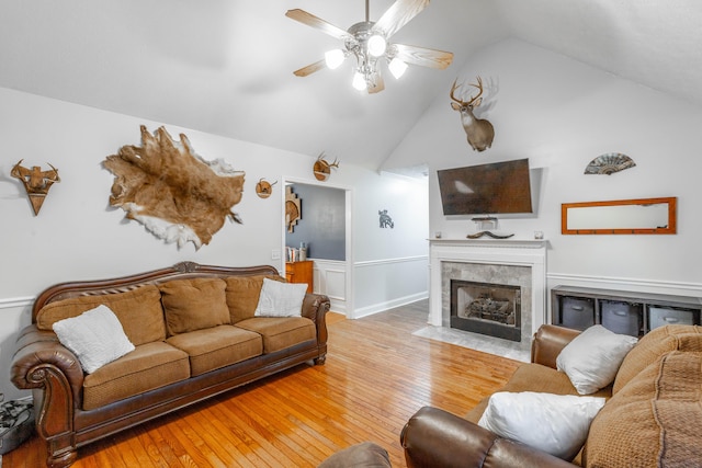 living room featuring a tiled fireplace, wood-type flooring, high vaulted ceiling, and ceiling fan