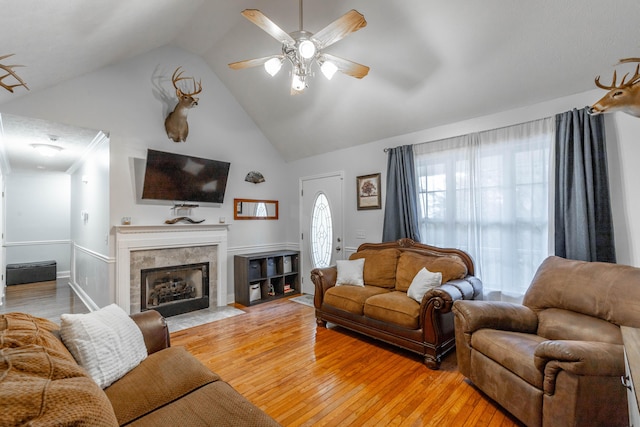 living room featuring ceiling fan, high vaulted ceiling, a fireplace, and light hardwood / wood-style flooring