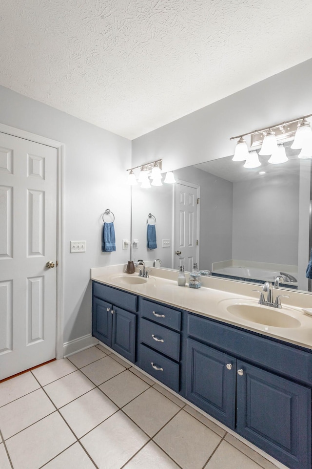 bathroom with tile patterned floors, vanity, and a textured ceiling