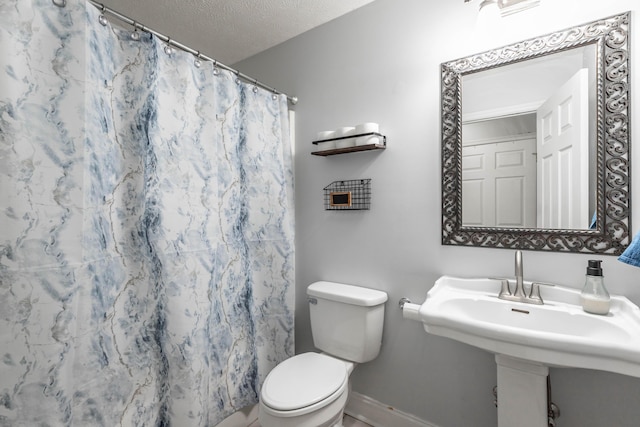 bathroom featuring walk in shower, toilet, and a textured ceiling