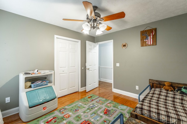 bedroom with hardwood / wood-style flooring, ceiling fan, and a closet