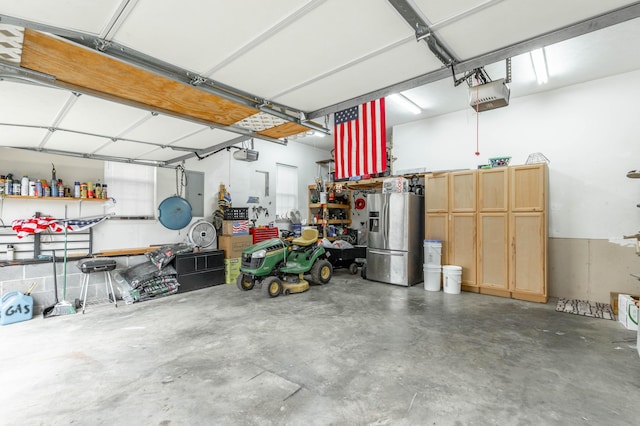 garage featuring a garage door opener and stainless steel refrigerator with ice dispenser