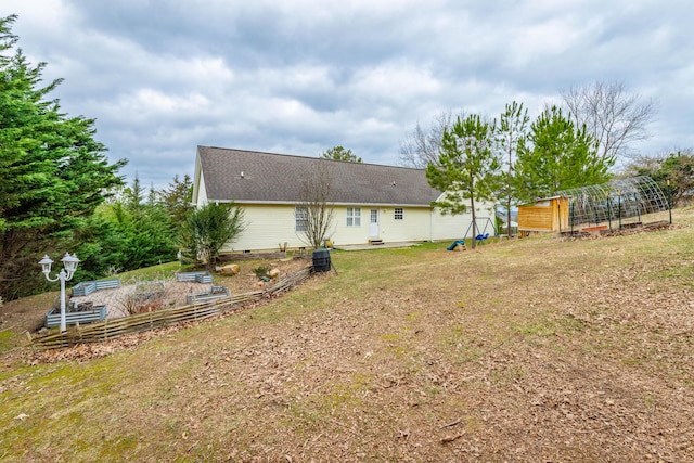 back of house with a yard and an outdoor structure