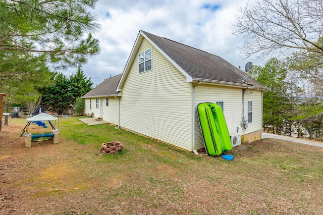 view of property exterior with ac unit, a fire pit, and a lawn